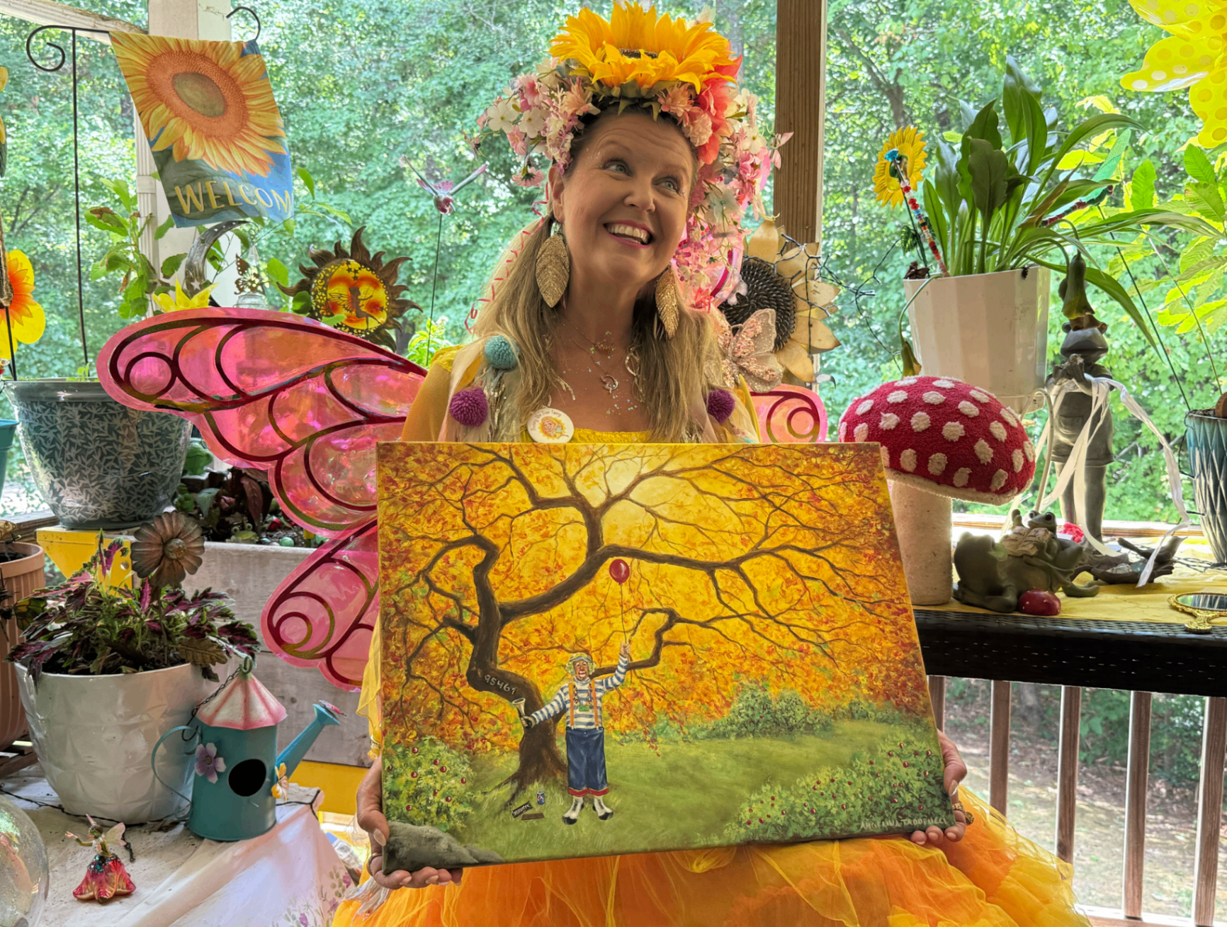 Sunny the Fun Fairy holding her painting of Recycle The Clown by the golden tree